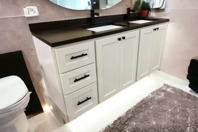 Elegant white vanity with dual sinks and dark countertops