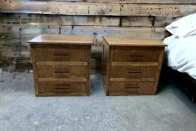 Two wooden nightstands against a wooden wall