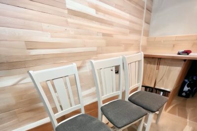 Wooden dining chairs against a light wood wall