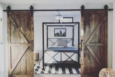 Double panel barn doors, leading into a brightly lit room with a picture hanging 