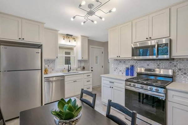 Modern kitchen with white cabinetry and steel appliances