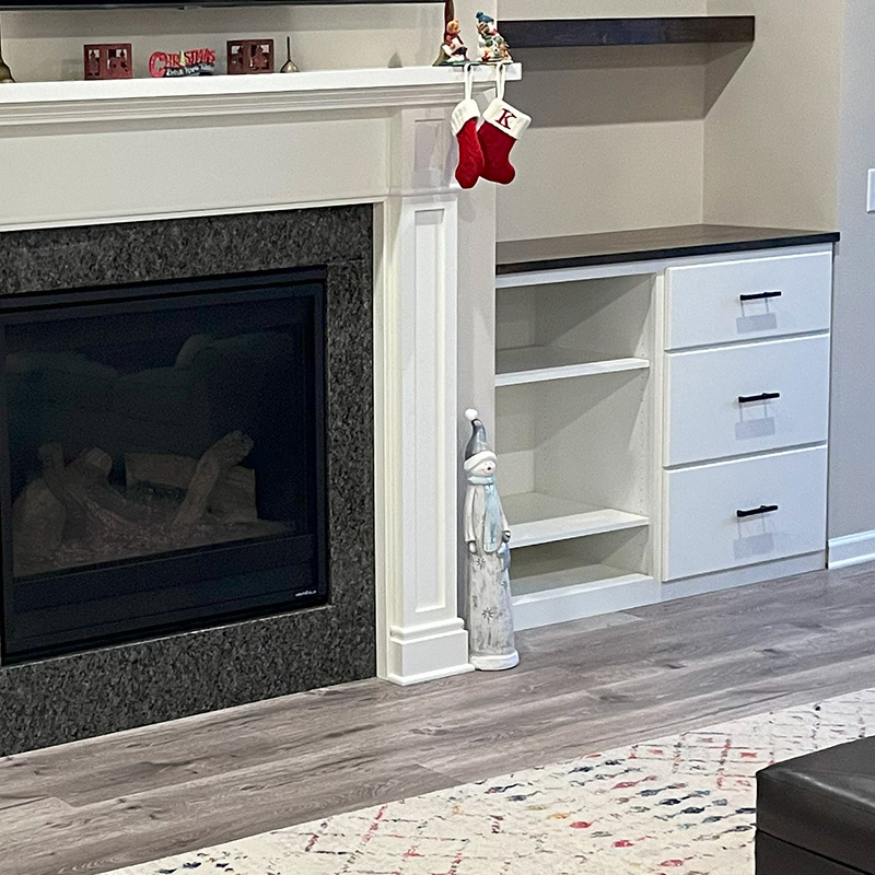 Built-in white shelving beside a fireplace in a living room