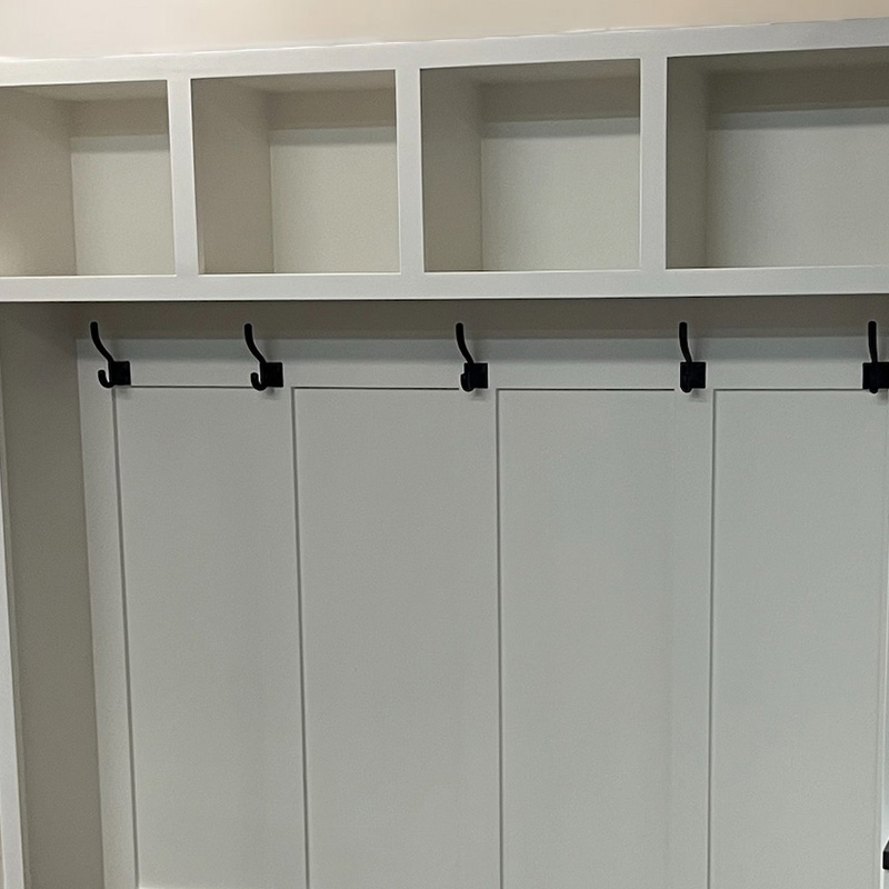 White shaker-style cabinets with black coat hooks